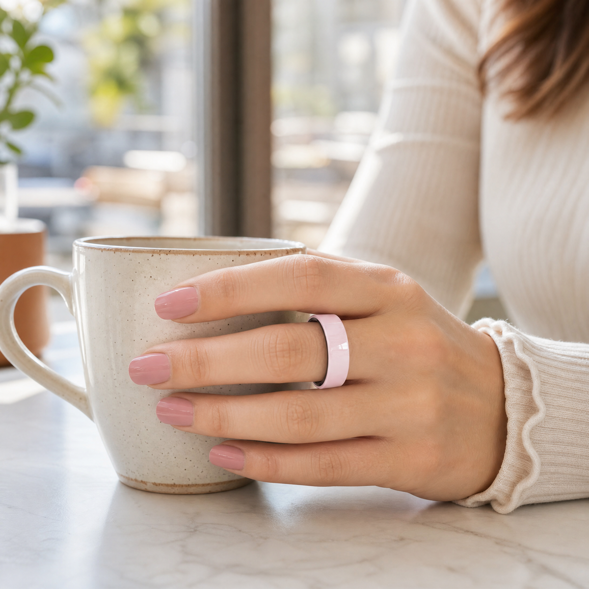 Hand wearing a Halo Pulse ring holding coffee