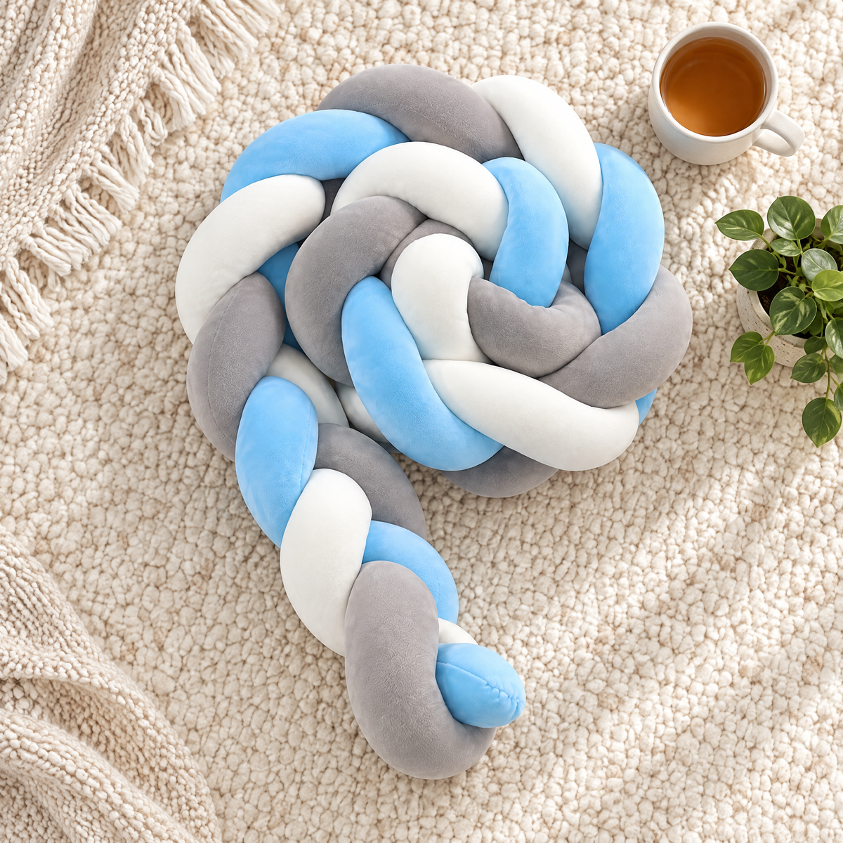 LoopNest braided knot pillow from above on a light rug
