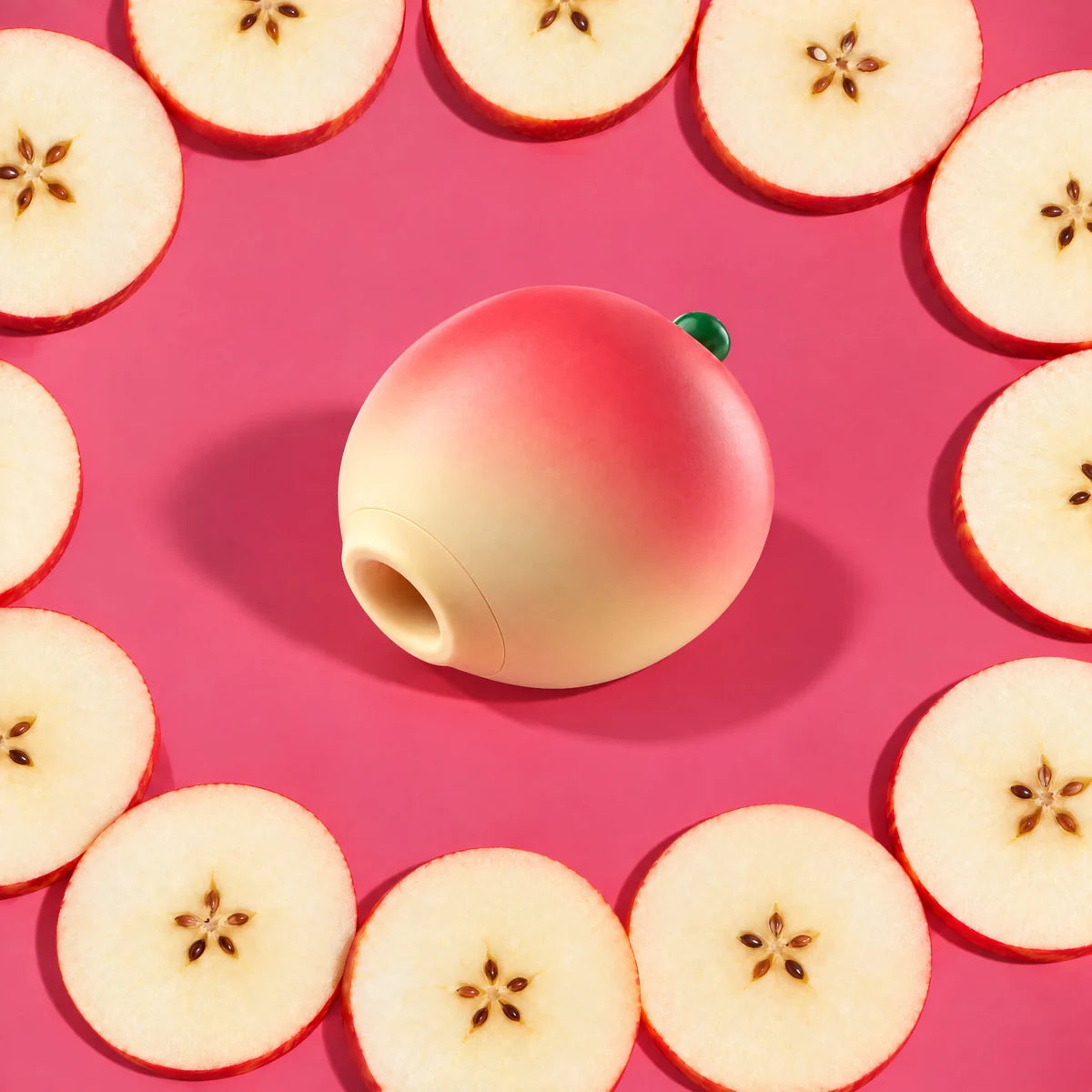 Pip apple suction massager on raspberry pink with apple slices