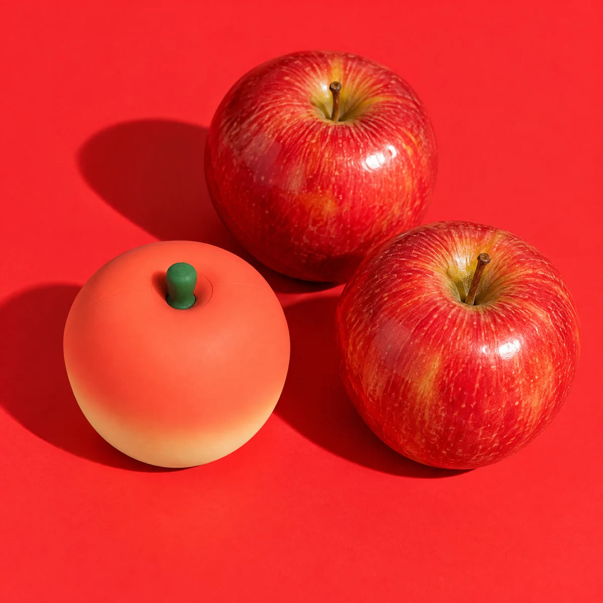 Pip next to two real apples